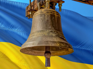 Eine Glocke vor der Ukrainischen Flagge